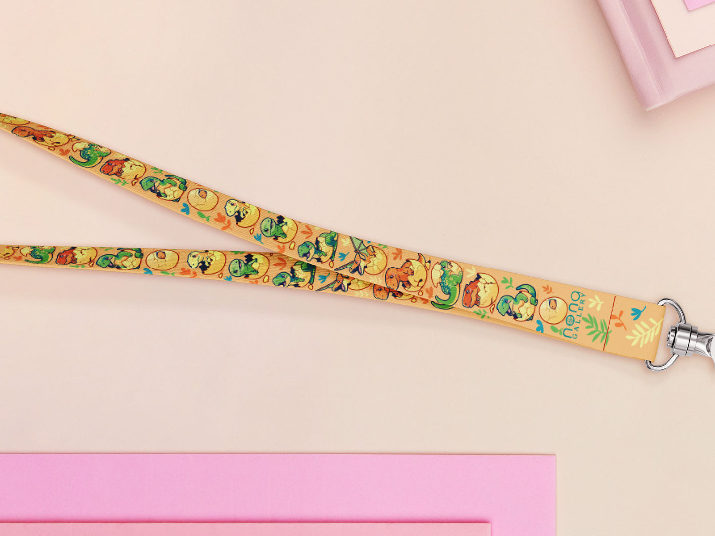 Cute full legth yellow lanyard with a double sided baby dinosuras hatcing from eggs pattern and silver swivel hook clasp.