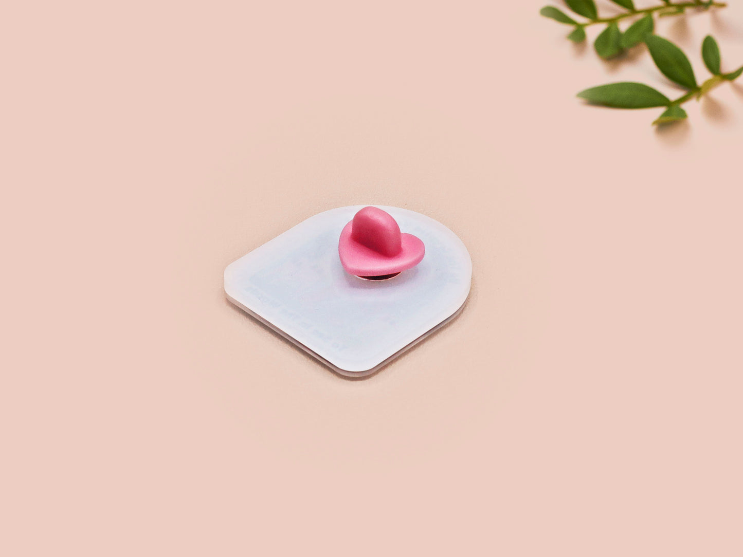 Clear acrylic pin badge with pink heart-shaped rubber pin back clasp. The design of the pin badge is a cute cartoon chibi fresno nightcrawlers, yeti bigfoot and alien UFO in a forest with the quote Be The Cryptid You Want To See In The Woods.