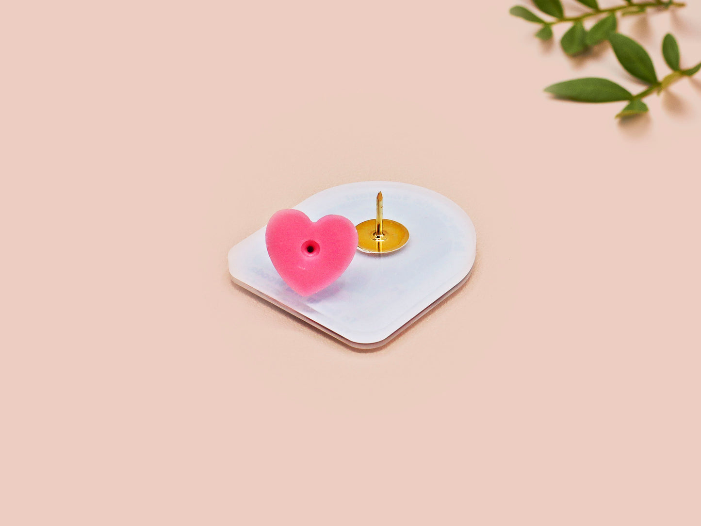 Clear acrylic pin badge with pink heart-shaped rubber pin back clasp. The design of the pin badge is a cute cartoon chibi fresno nightcrawlers, yeti bigfoot and alien UFO in a forest with the quote Be The Cryptid You Want To See In The Woods.