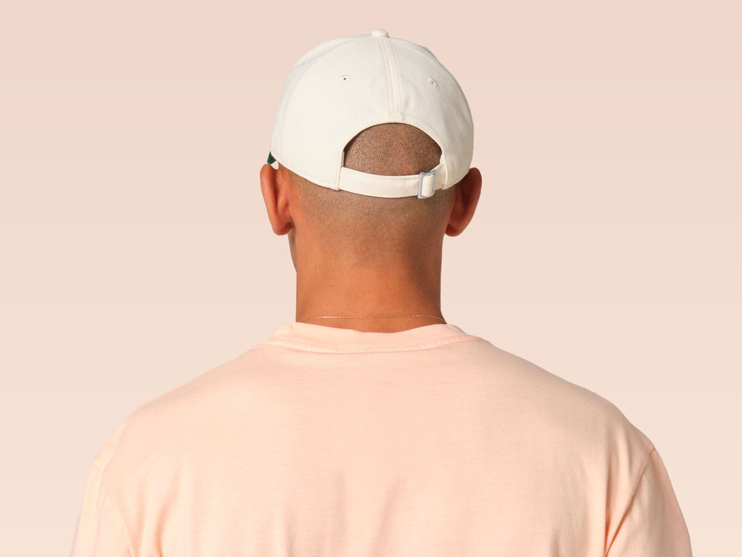 Vintage contrast cream and green peek baseball cap with an embroidered design of a cartoon bird and the quote bird brain.