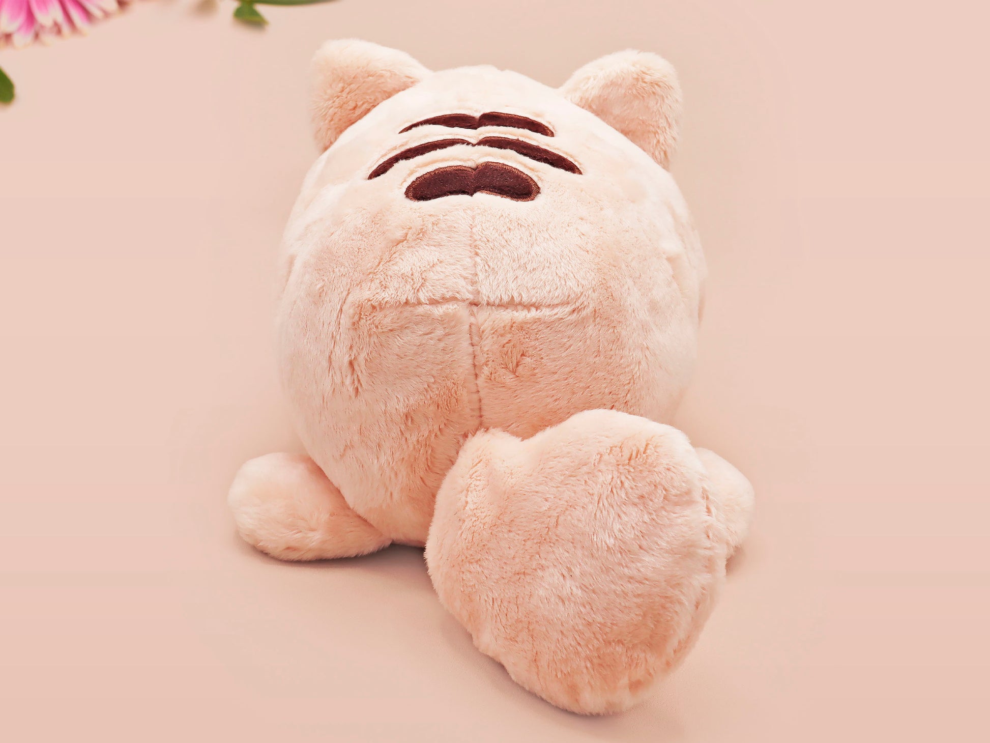 An adorable fluffy cat plushie toy with cute embroidered eyes, facial expression and applique stripes and pawprint toe beans, with a hang tag describing the cat as Brenda.