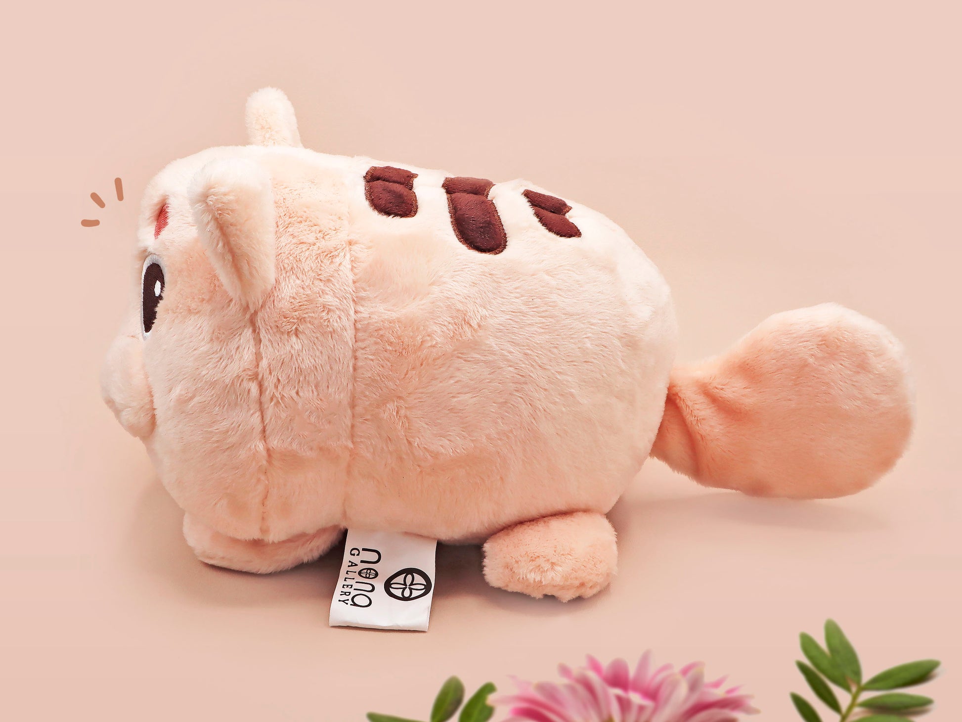 An adorable fluffy cat plushie toy with cute embroidered eyes, facial expression and applique stripes and pawprint toe beans, with a hang tag describing the cat as Brenda.