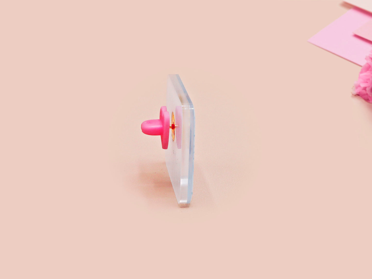A clear acrylic pin badge with a pink heart-shaped pin back clasp. The design of the pin badge is of a cute chibi blue fish with the quote buy a man eat fish he day teach fish man to a lifetime.