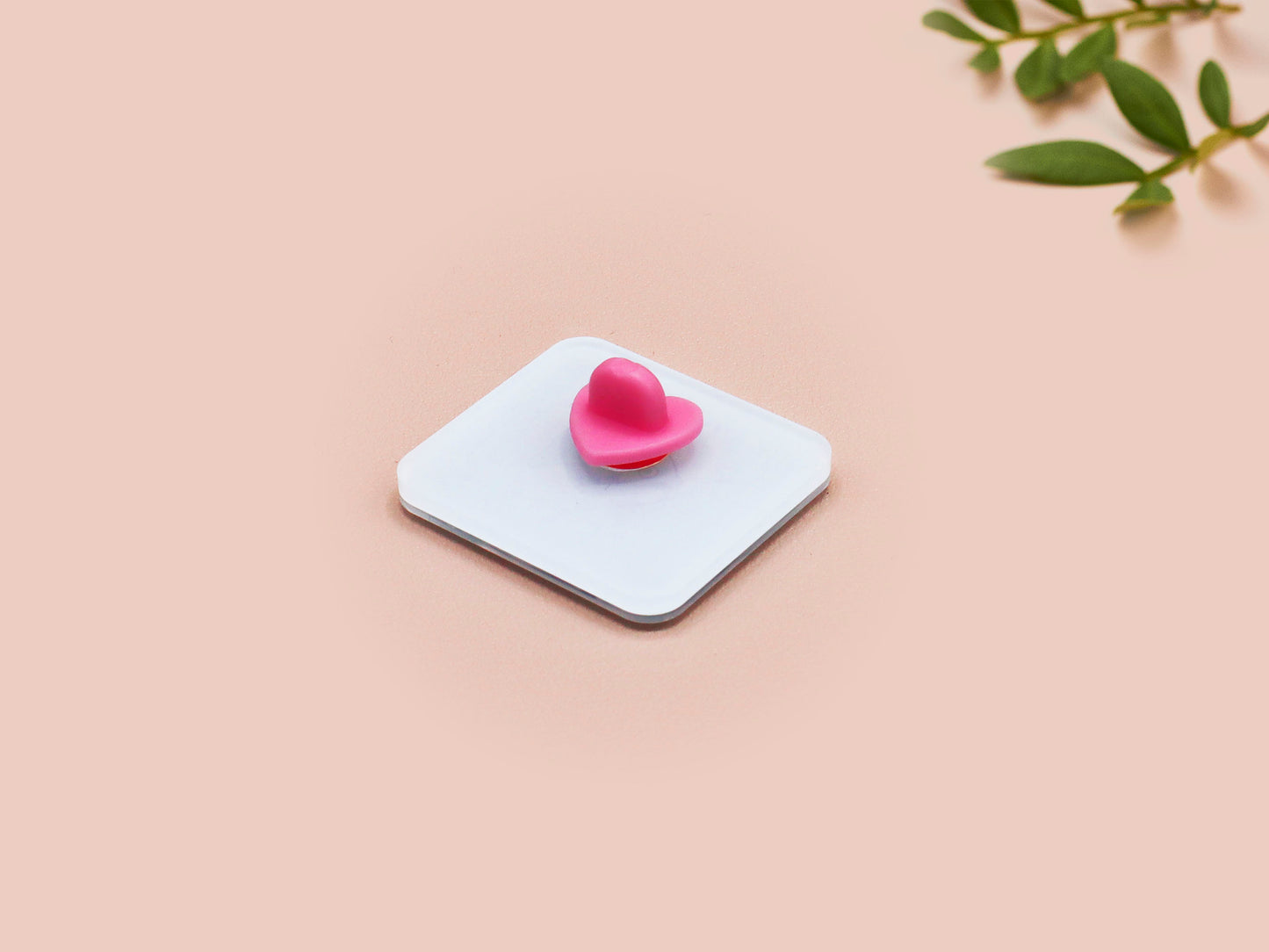 A clear acrylic pin badge with a pink heart-shaped pin back clasp. The design of the pin badge is of a cute chibi blue fish with the quote buy a man eat fish he day teach fish man to a lifetime.