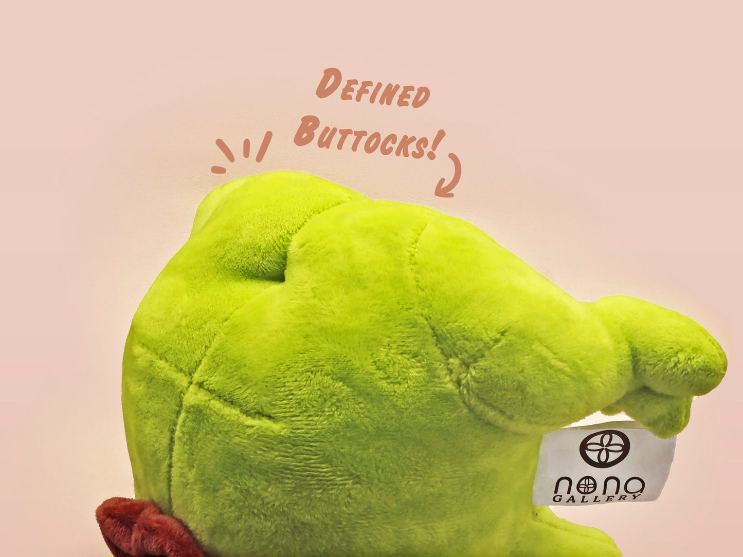 An adorable green frog plushie toy with cute embroidered eyes and facial expression, wearing a cowboy hat with a brown ribbon, and a hang tag describing the frog as Carl.