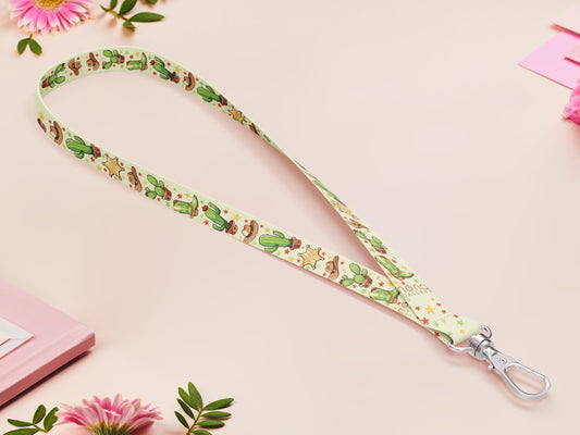 Cute full legth yellow and green lanyard with a double sided cowboy western and cactus themed pattern and silver swivel hook clasp.