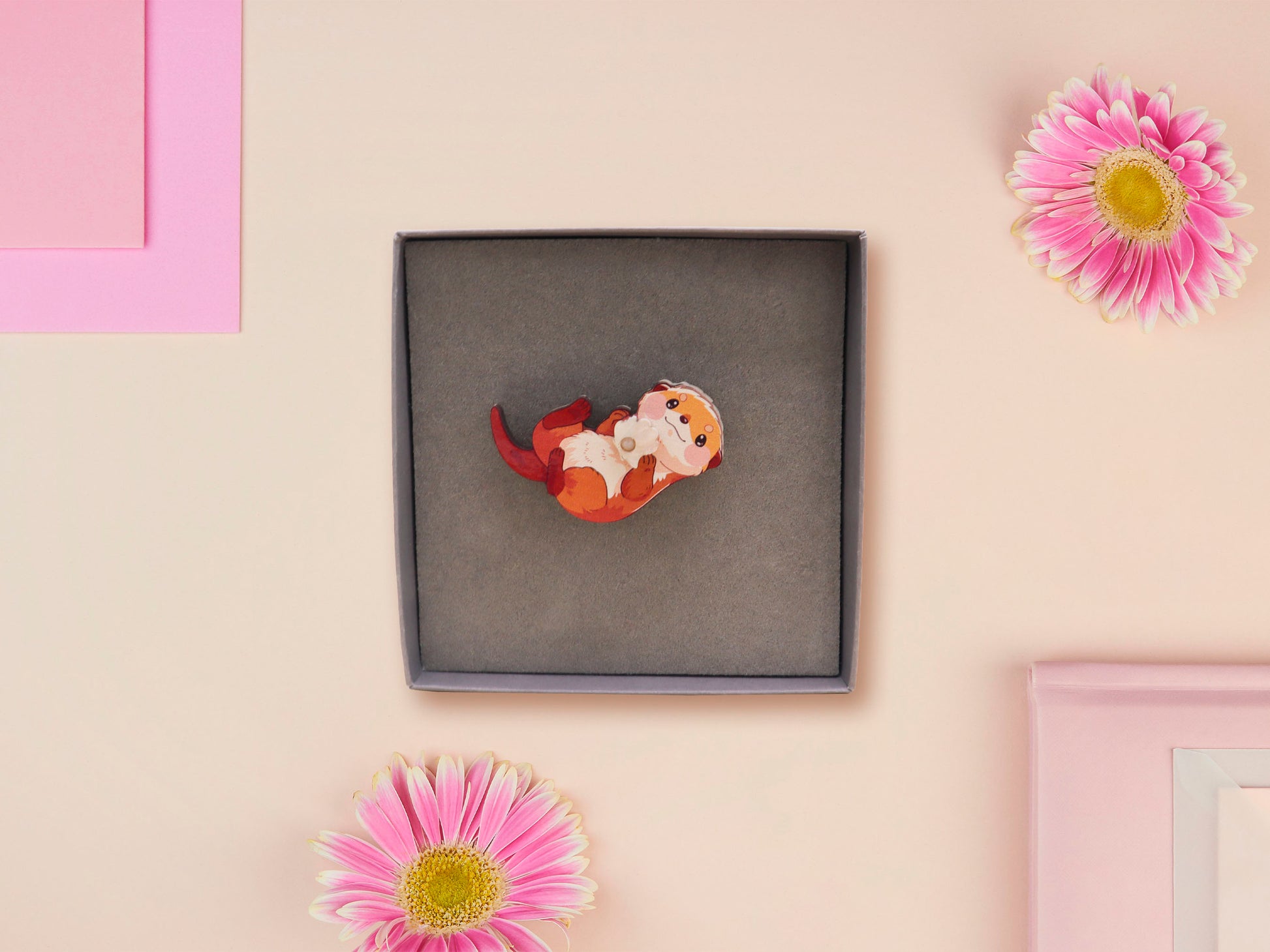 An adorable cute otter holding a clam seashell with a pearl inside brooch pin badge made of wood and glitter pearlescent acrylic with a gold chain is displayed in a velvet gift box with a unique cute otter sleeve design.