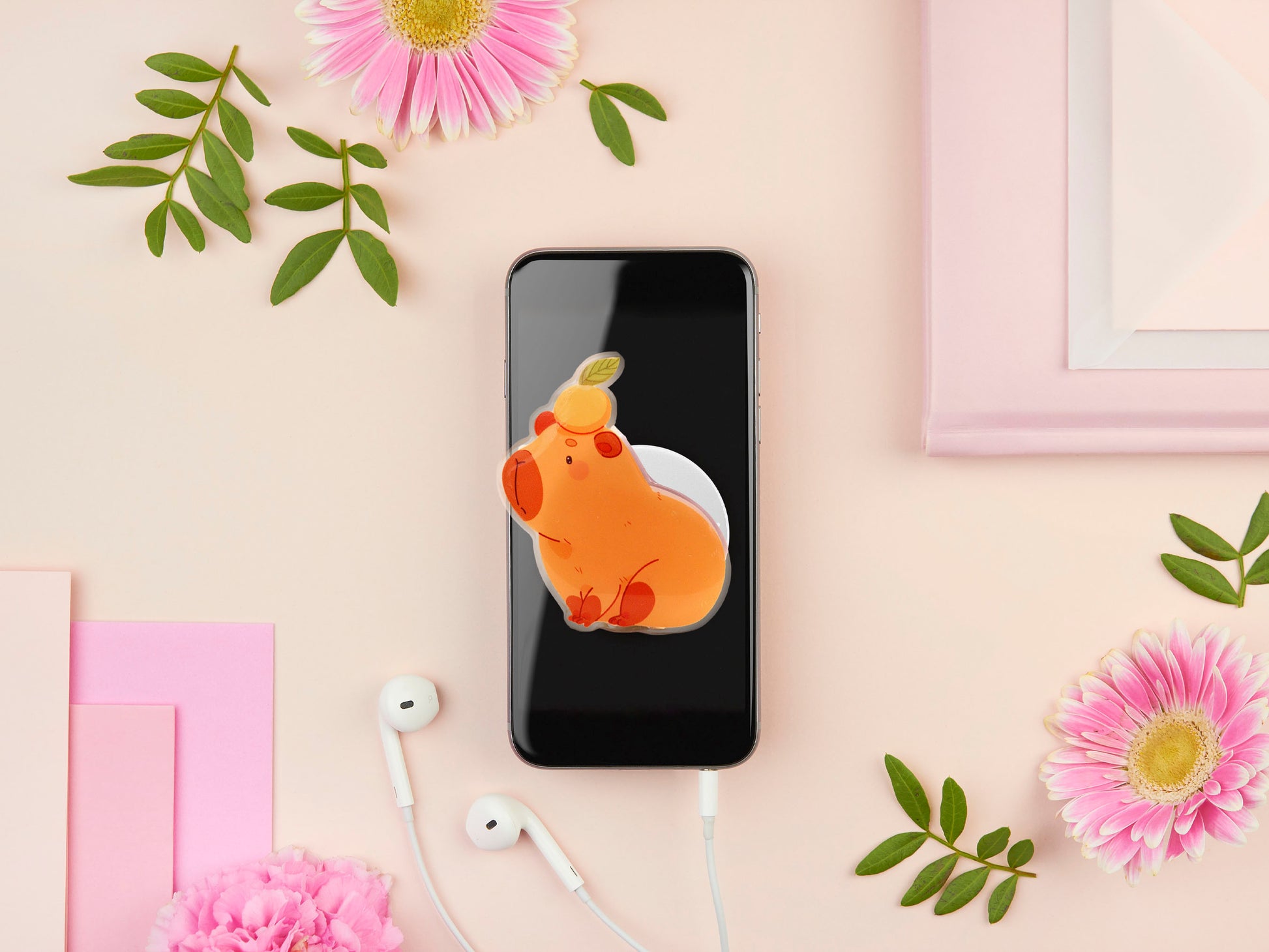 Cute acrylic popsocket phone grip of a capybara with an orange on it's head