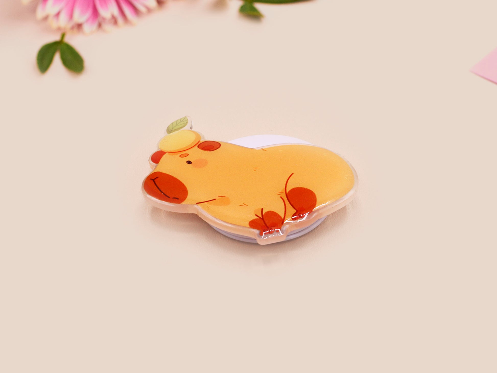 Cute acrylic popsocket phone grip of a capybara with an orange on it's head