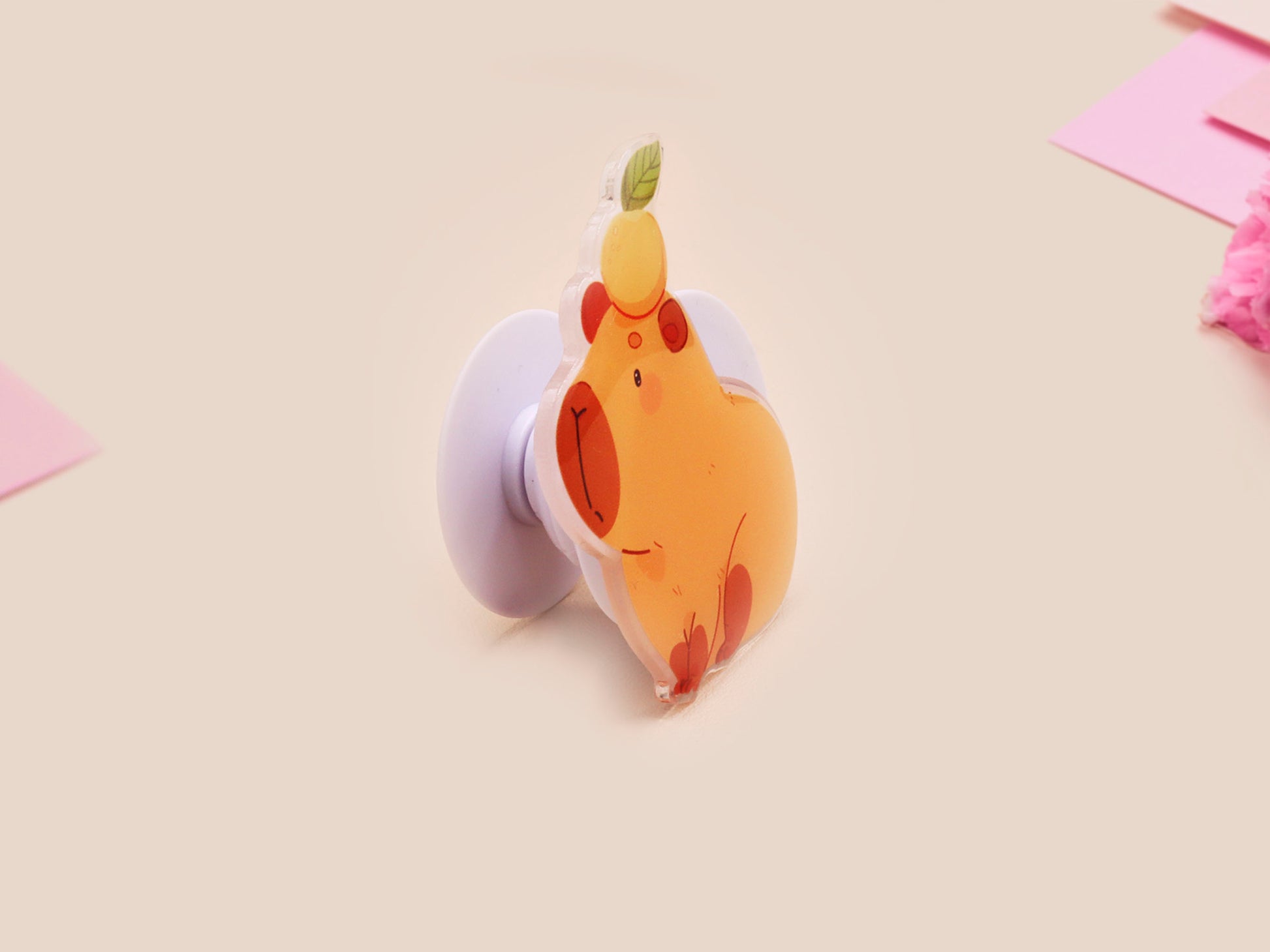Cute acrylic popsocket phone grip of a capybara with an orange on it's head