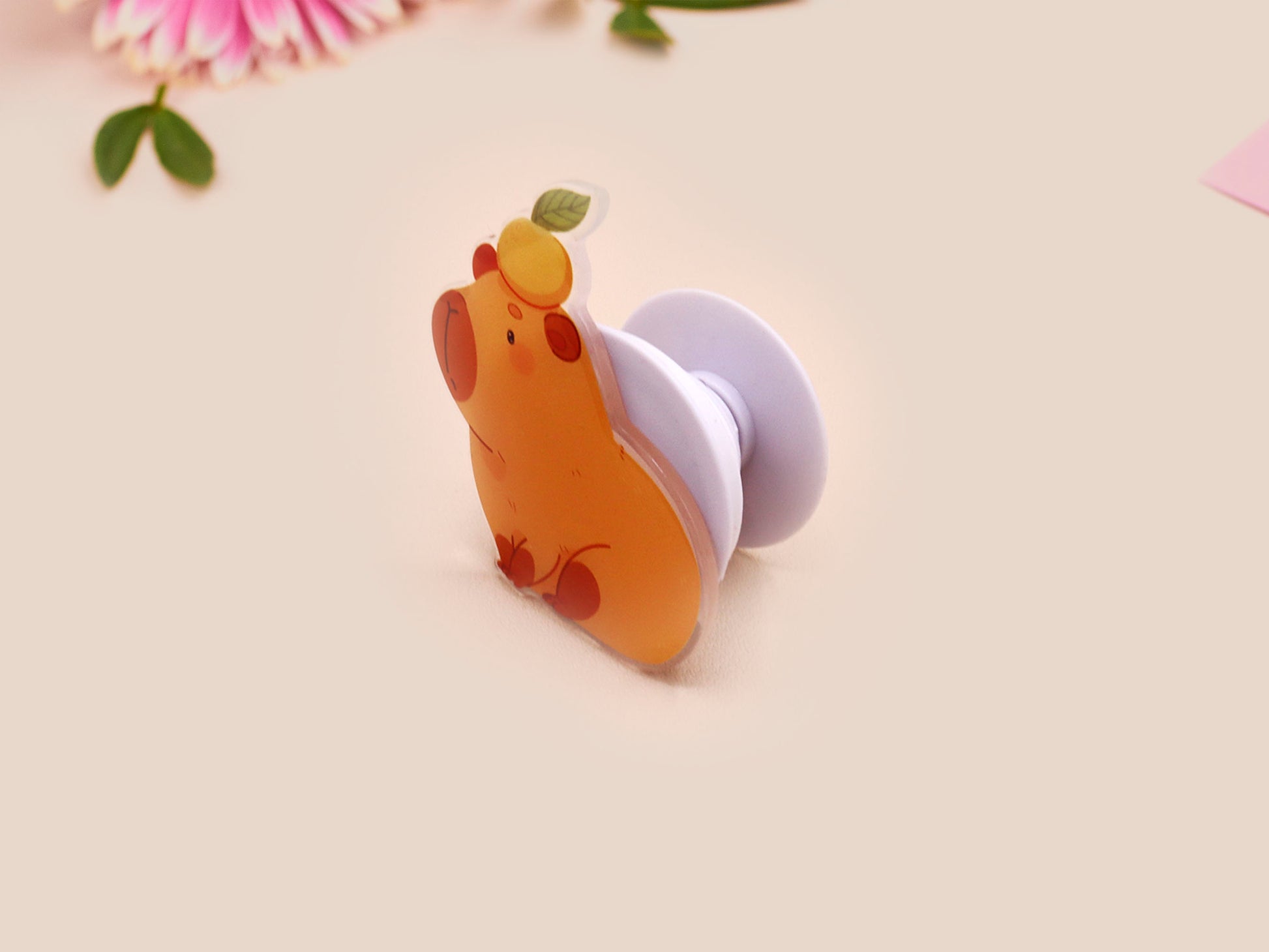 Cute acrylic popsocket phone grip of a capybara with an orange on it's head