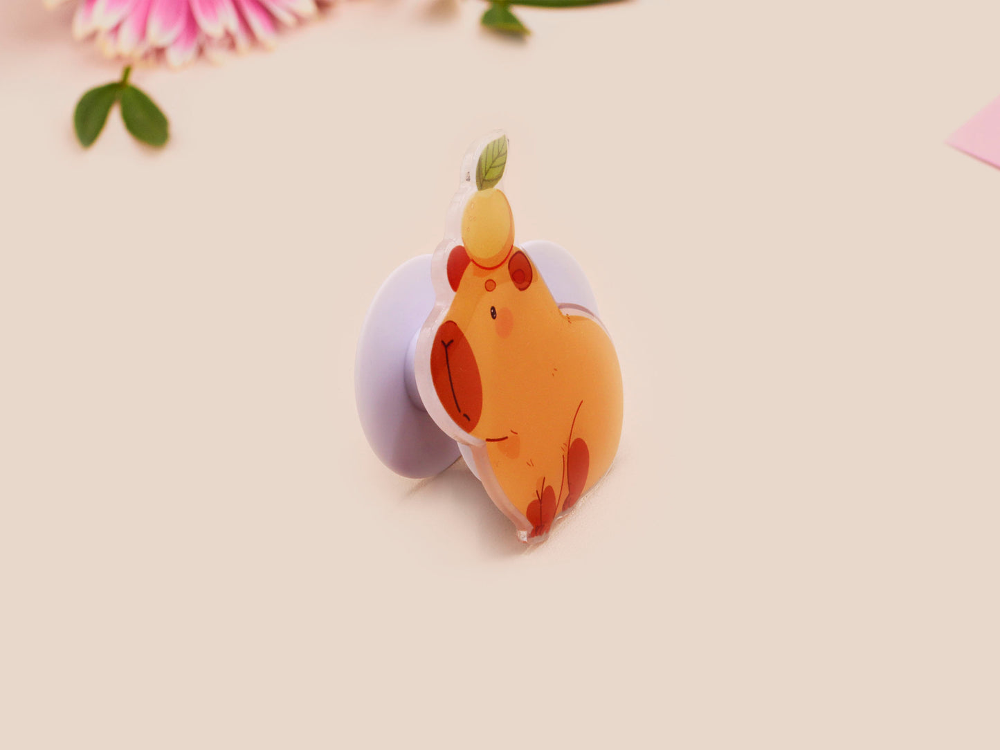 Cute acrylic popsocket phone grip of a capybara with an orange on it's head