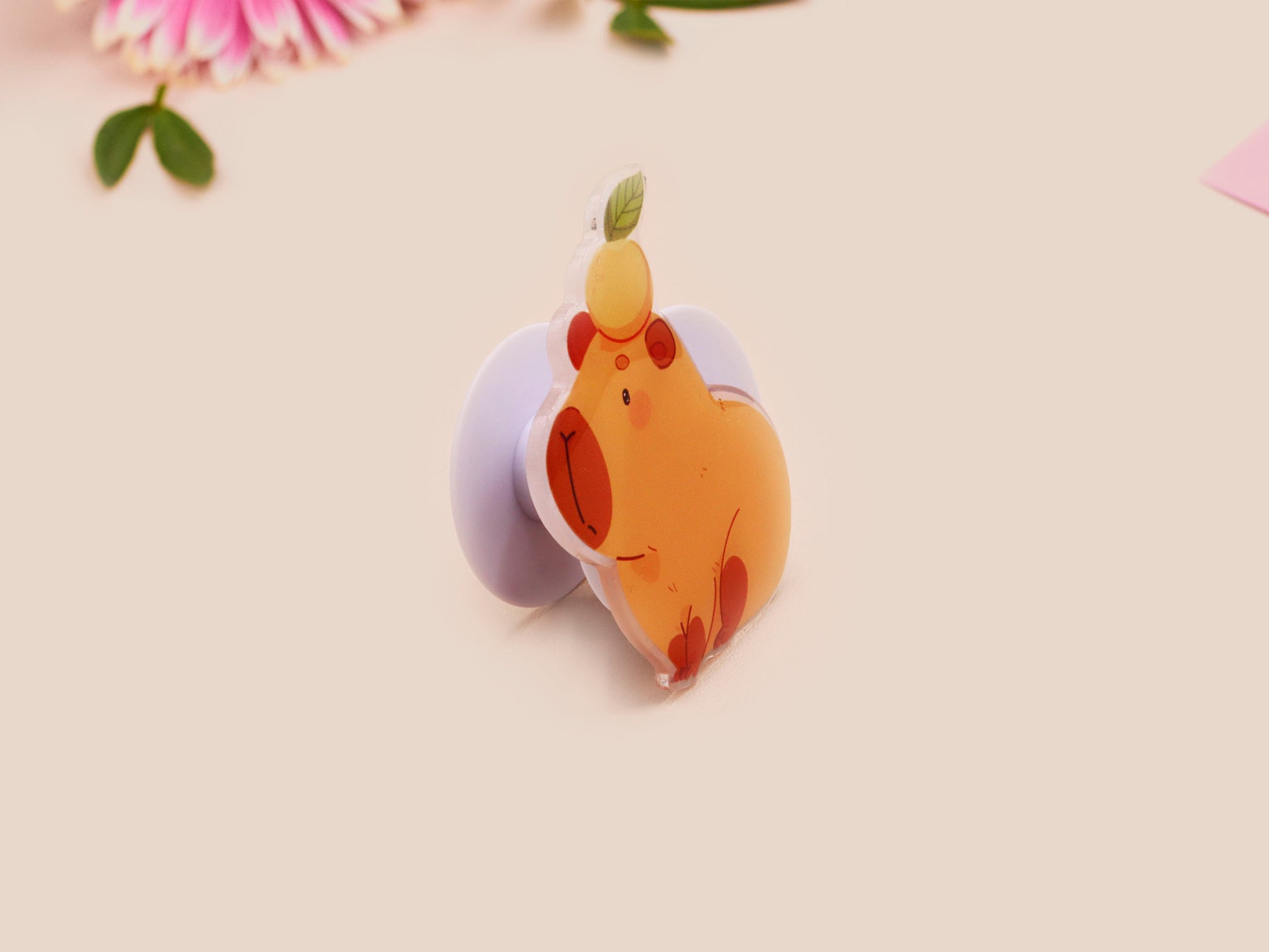 Cute acrylic popsocket phone grip of a capybara with an orange on it's head