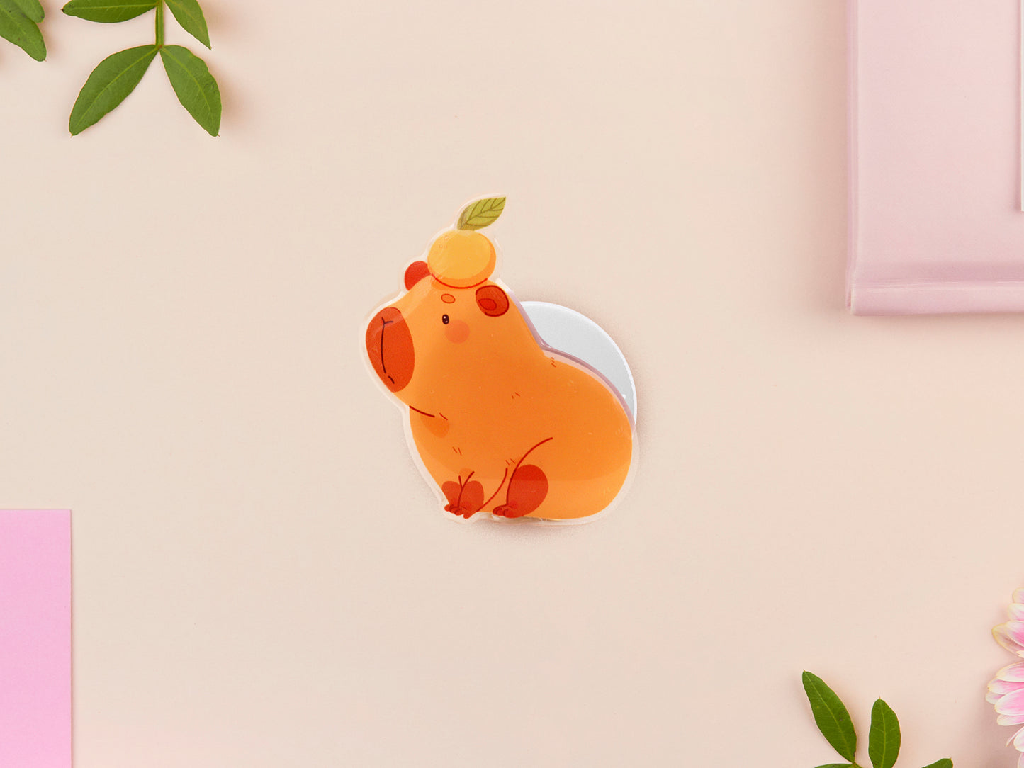 Cute acrylic popsocket phone grip of a capybara with an orange on it's head