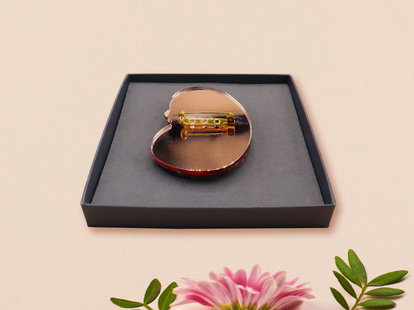 An adorable shy pangolin aardvark holding a heart brooch pin badge made of wood and glitter mirror acrylic with a gold chain is displayed in a velvet gift box with a unique cute Pangolin sleeve design.