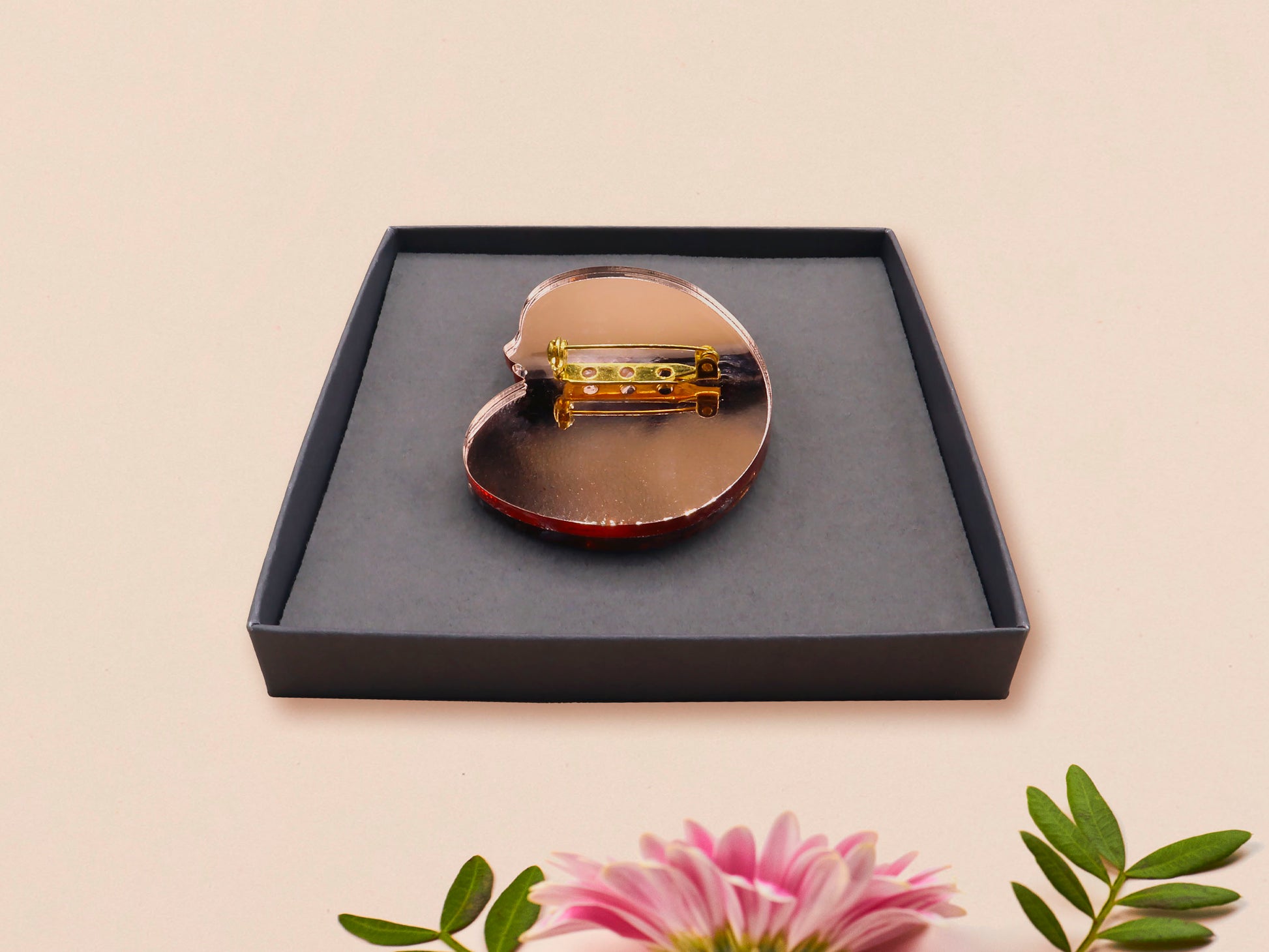 An adorable shy pangolin aardvark holding a heart brooch pin badge made of wood and glitter mirror acrylic with a gold chain is displayed in a velvet gift box with a unique cute Pangolin sleeve design.