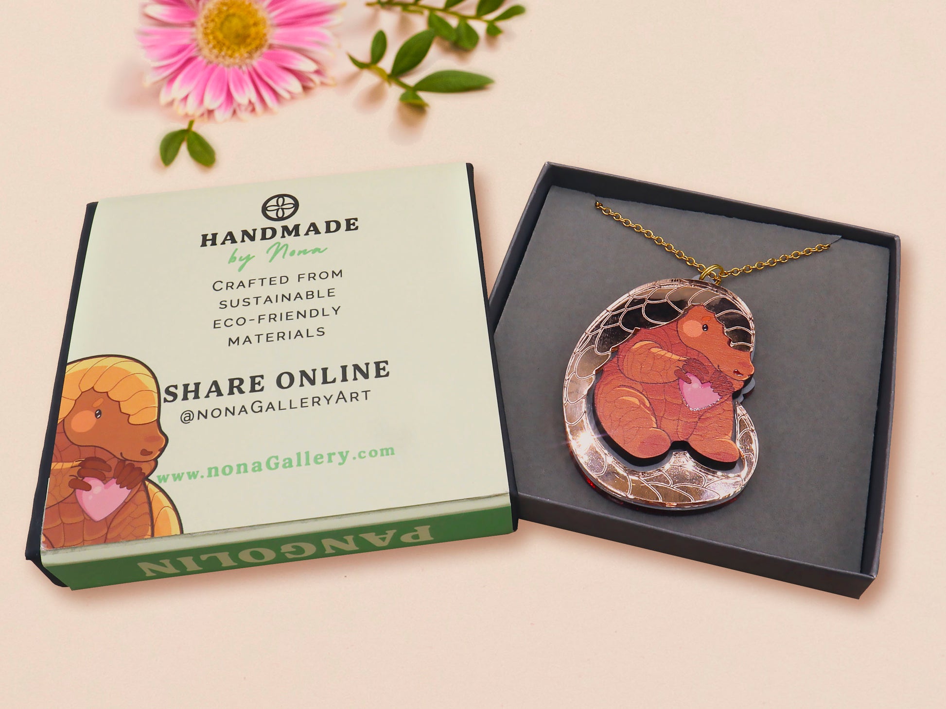 An adorable shy pangolin aardvark holding a heart necklace made of wood and glitter mirror acrylic with a gold chain is displayed in a velvet gift box with a unique cute Pangolin sleeve design.