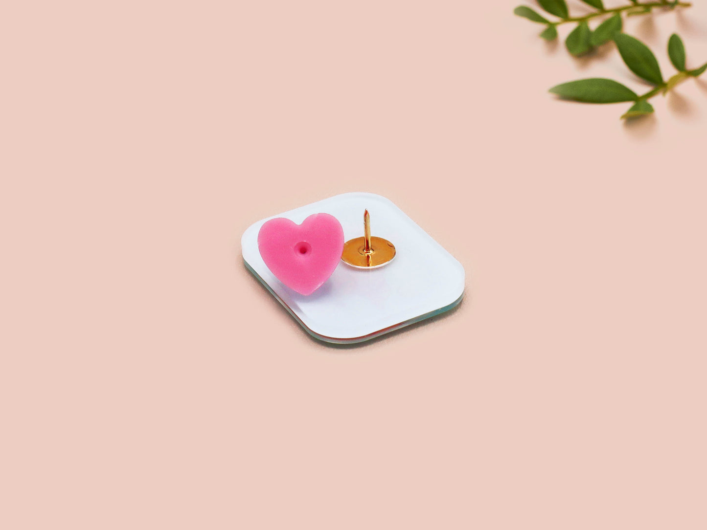 A clear acrylic pin badge with a pink heart-shaped pin back clasp. The design of the pin badge is of a cute relaxing capybara in water with a face mask with the quote don't worry be cappy.