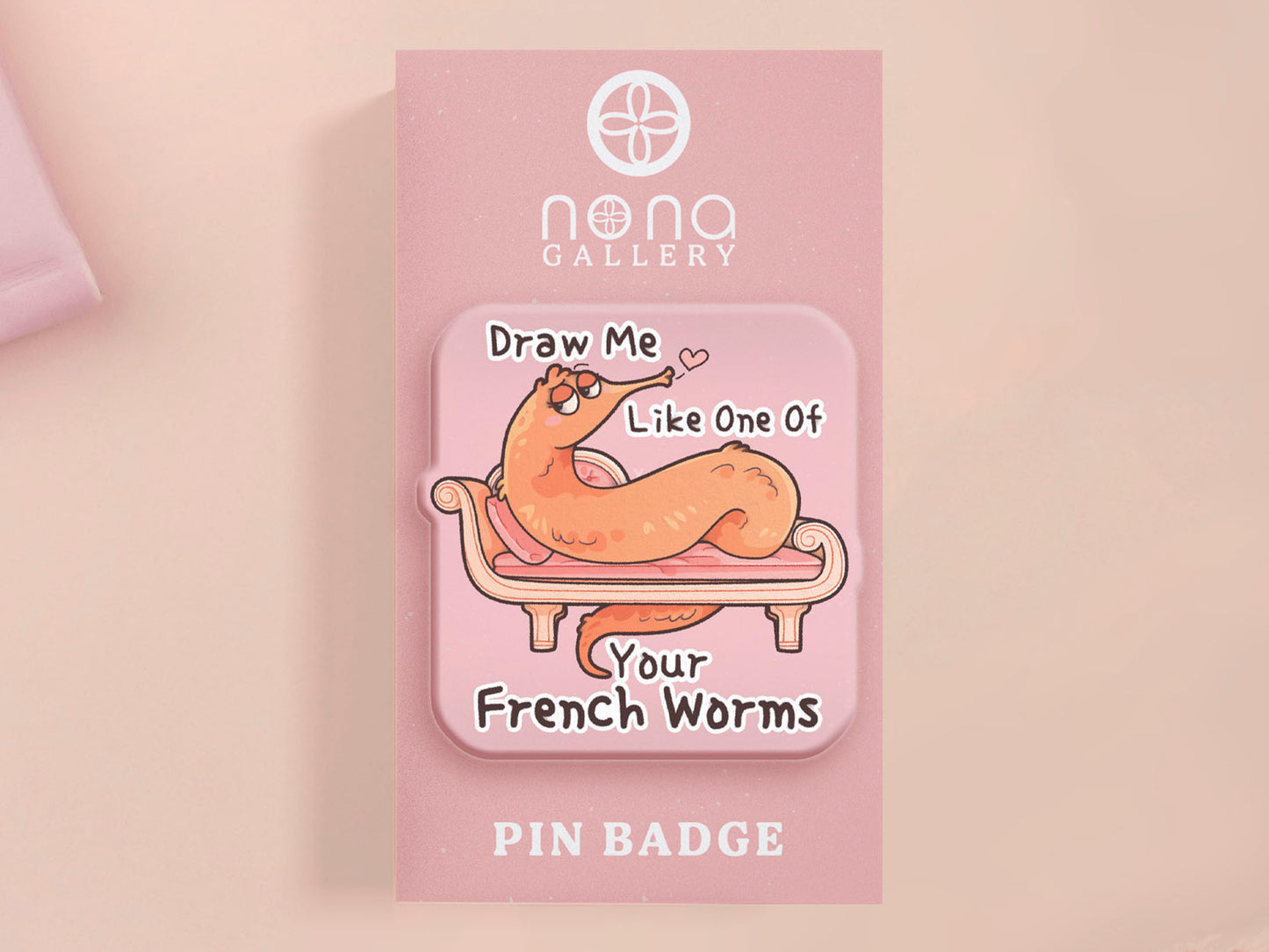 A cute transparent acrylic pin badge with a pink heart-shaped rubber clasp pin back. The design of the pin badge is a cartoon orange worm on a sting sitting on a sofa chaise lounge with the titanic quote Draw Me Like One of Your French Worms