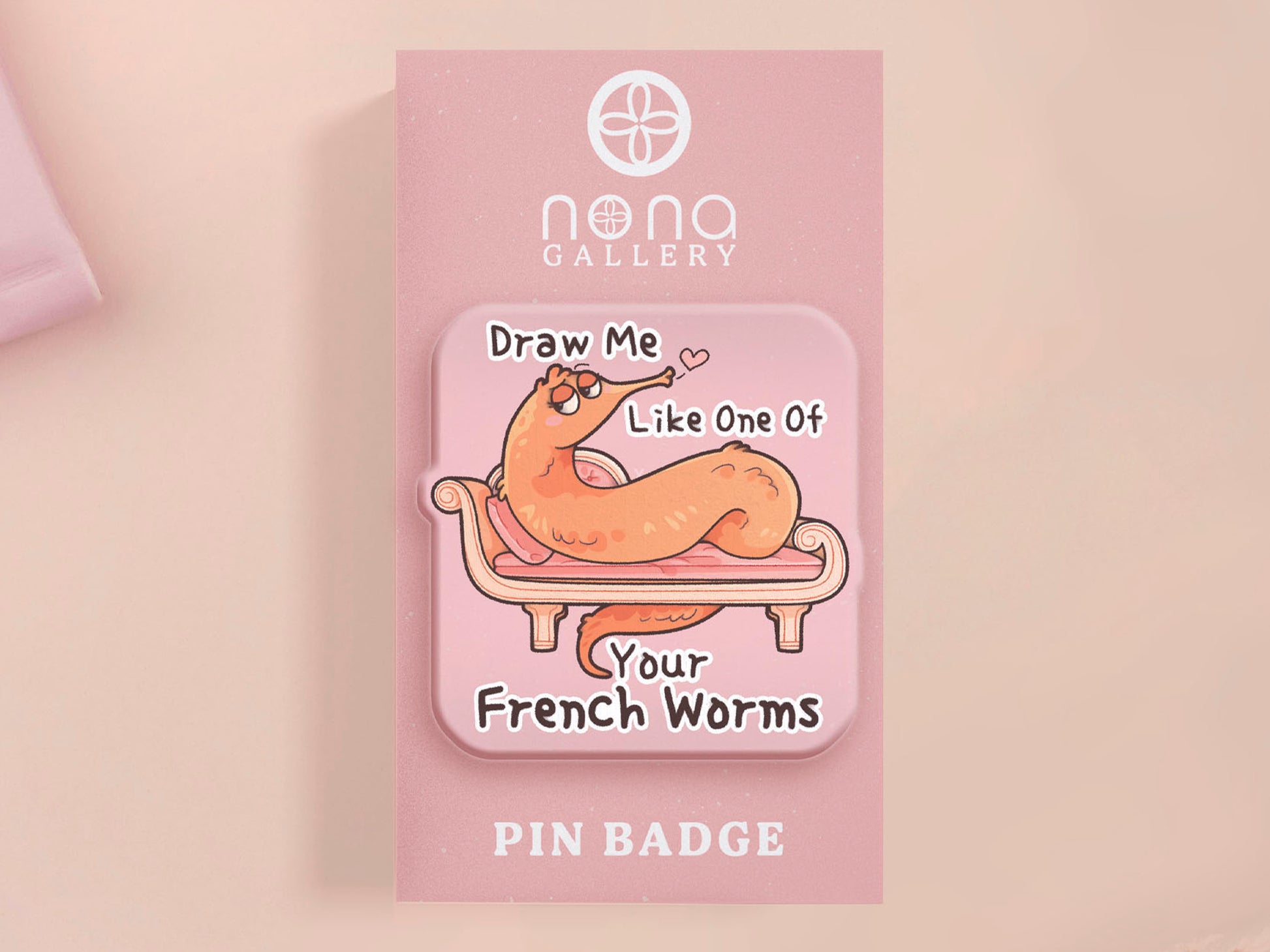 A cute transparent acrylic pin badge with a pink heart-shaped rubber clasp pin back. The design of the pin badge is a cartoon orange worm on a sting sitting on a sofa chaise lounge with the titanic quote Draw Me Like One of Your French Worms