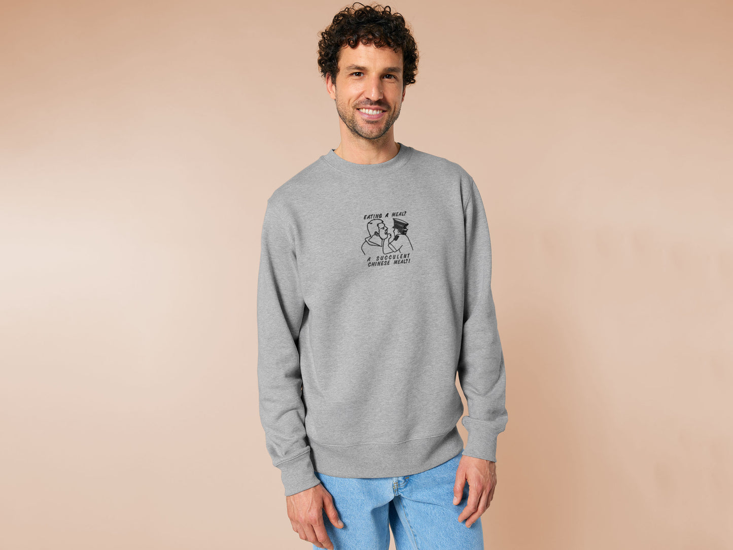An embroidered light grey sweater design of the Australian Jack Karlson being arrested while he shouts Eating A Meal? A Succulent Chinese Meal?!