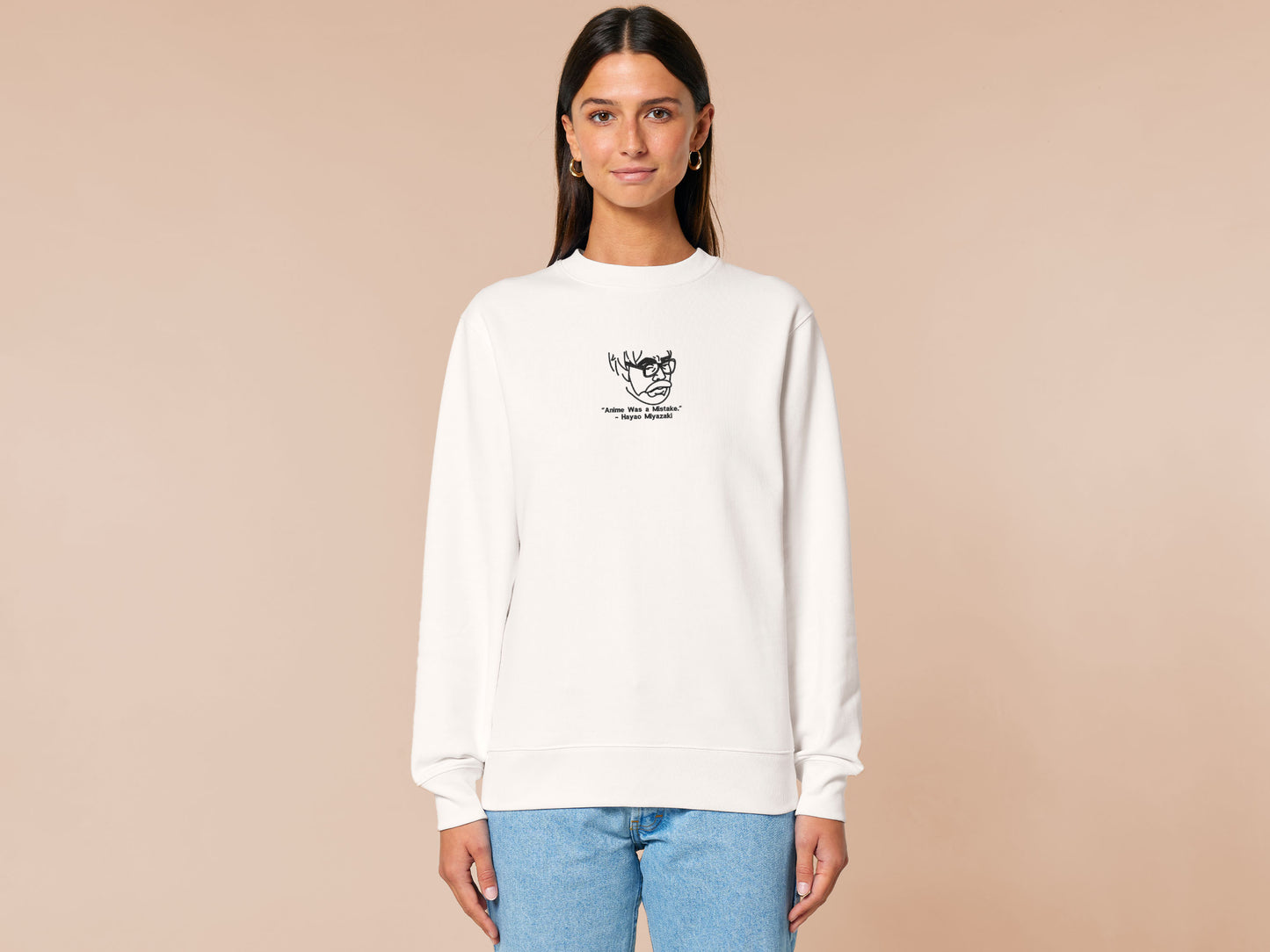 A off white crew neck long sleeve sweater, with an embroidered black thread design of a portrait of a depressed Hayao Miyazaki the creator of Studio Ghibli with text underneath that reads "Anime Was A Mistake." - Hayao Miyazaki