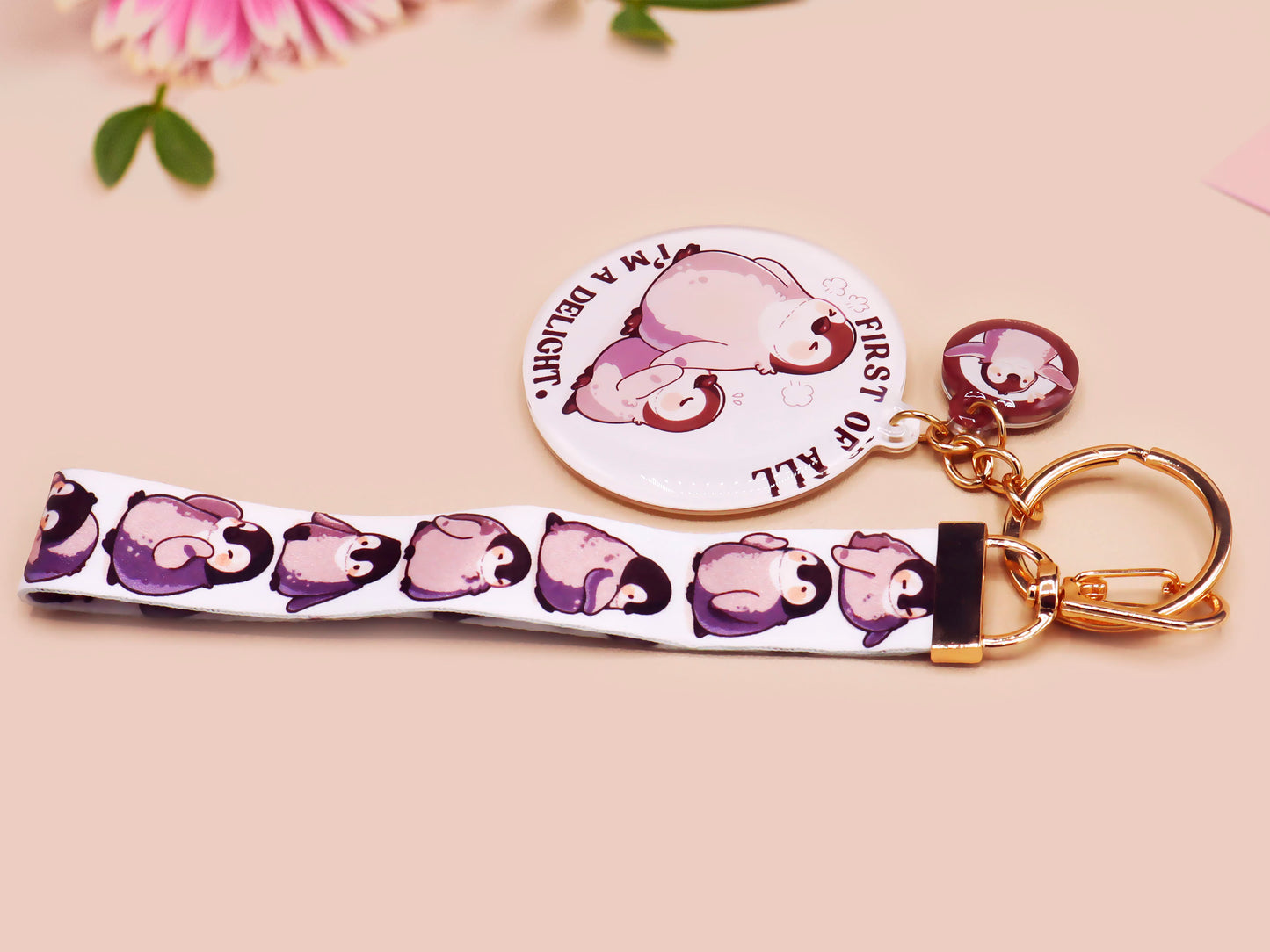 Acrylic epoxy baby penguin keychain with a large acrylic charm of two baby penguins with the quote first of all I'm a delight, a smaller charm of a cute penguin and a matching baby emperor penguin lanyard.