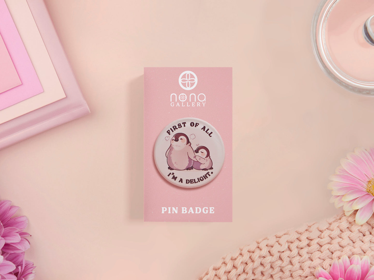A clear acrylic pin badge with a pink heart-shaped pin back clasp. The design of the pin badge is of a cute baby penguin chicks squabbling with the quote first of all I'm a delight.