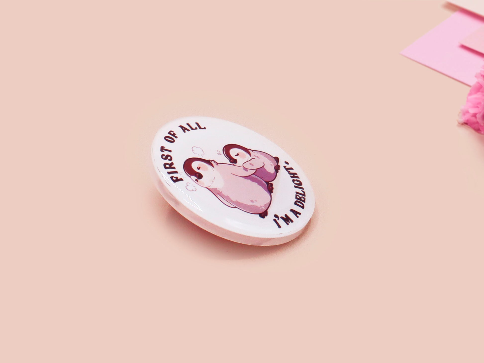 A clear acrylic pin badge with a pink heart-shaped pin back clasp. The design of the pin badge is of a cute baby penguin chicks squabbling with the quote first of all I'm a delight.