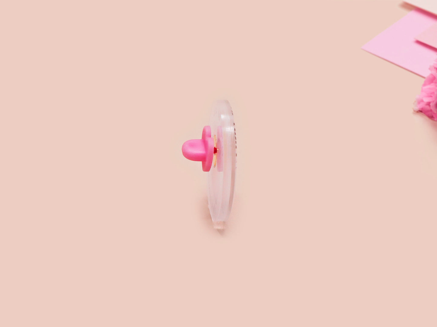 A clear acrylic pin badge with a pink heart-shaped pin back clasp. The design of the pin badge is of a cute baby penguin chicks squabbling with the quote first of all I'm a delight.