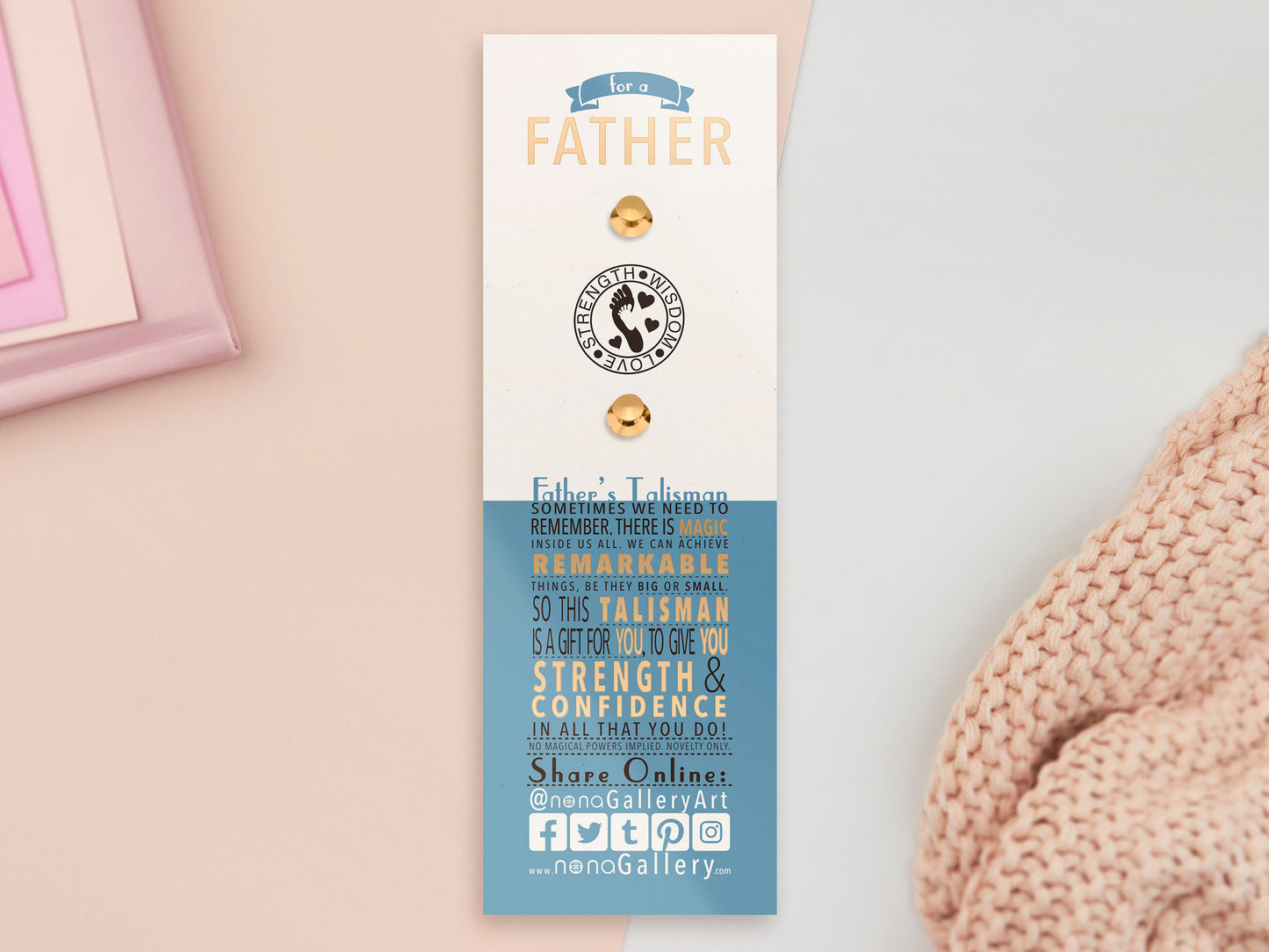 The back of the long white and blue backing card with gold accents. The backing card details the symbolism of the different design elements of the Father's Talisman pin. Also shown is the two gold locking pin backs attached to the card.