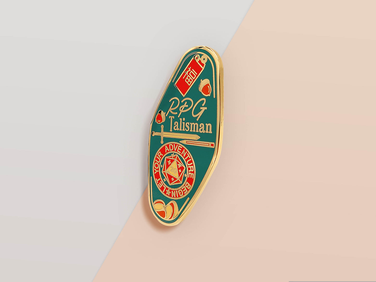 Gold Enamel Talisman Pin with red and blue design and the words RPG Talisman, Let Your Adventure Begin. The pins design includes a D20 dice and a sword and pencil, Hongbao red envelope, as well as acorns and crystals.