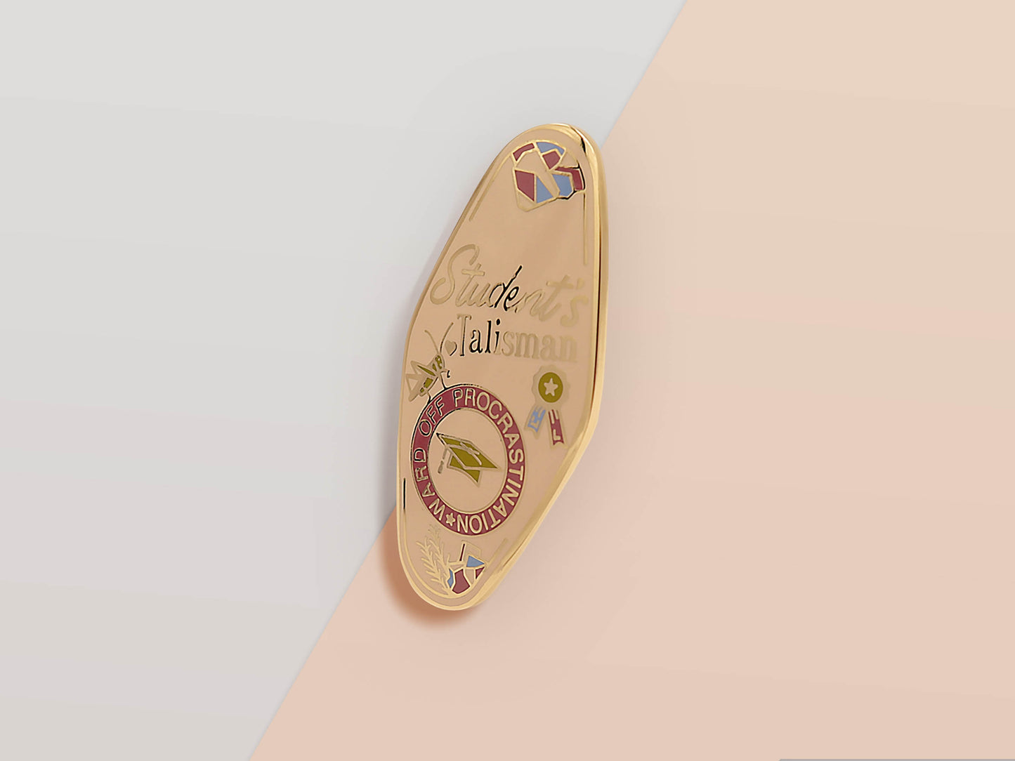 Gold Enamel Talisman Pin with white design and the words Student's Talisman, Ward of procrastination. The pins design includes a graduation cap and a rosette, a grass hopper, as well as plants and crystals.