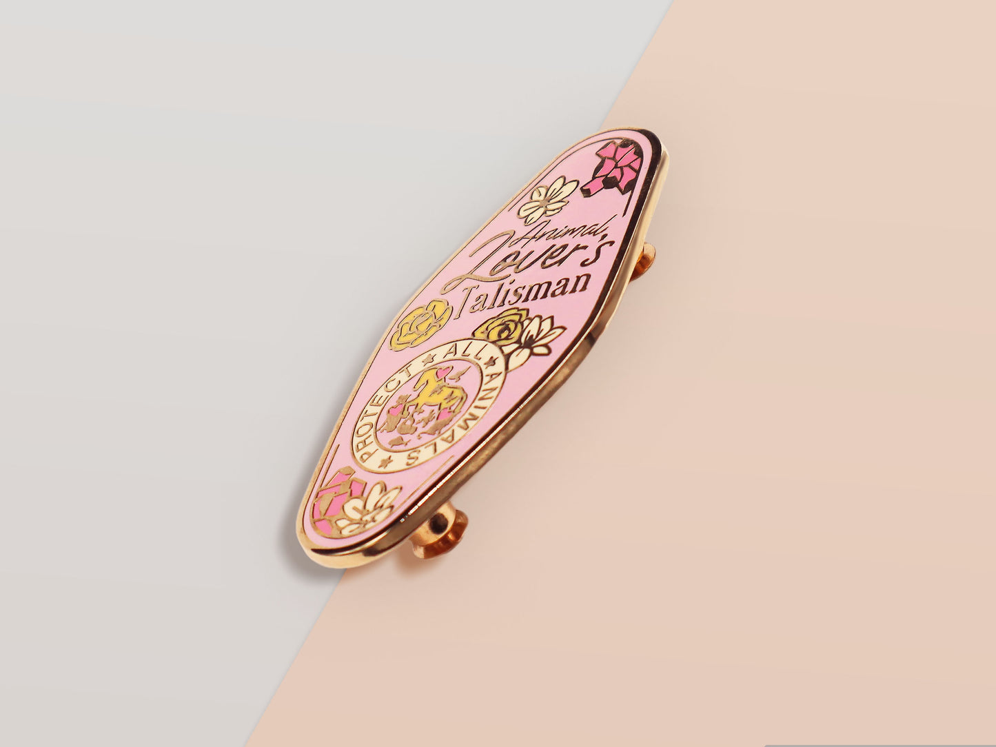 An Animal Lover's Talisman gold enamel pin on a gold foiled backing card that outlines the symbolism of the talisman including information and imagery on Magnolia flowers, yellow roses, and aragonite star clusters
