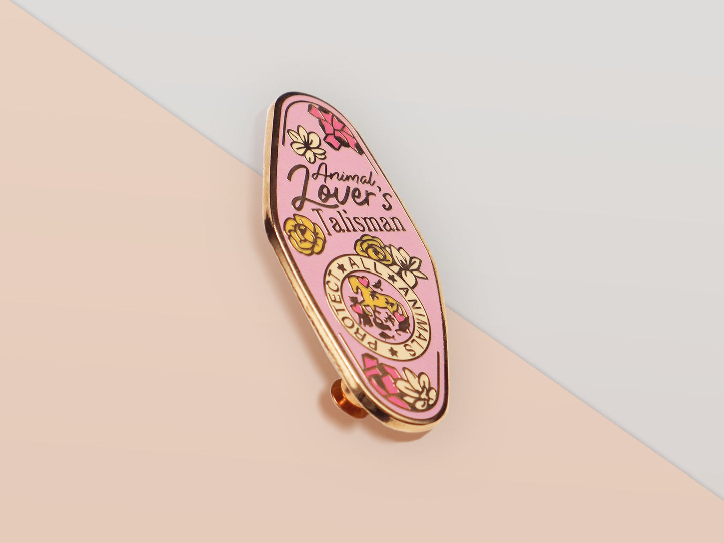 An Animal Lover's Talisman gold enamel pin on a gold foiled backing card that outlines the symbolism of the talisman including information and imagery on Magnolia flowers, yellow roses, and aragonite star clusters