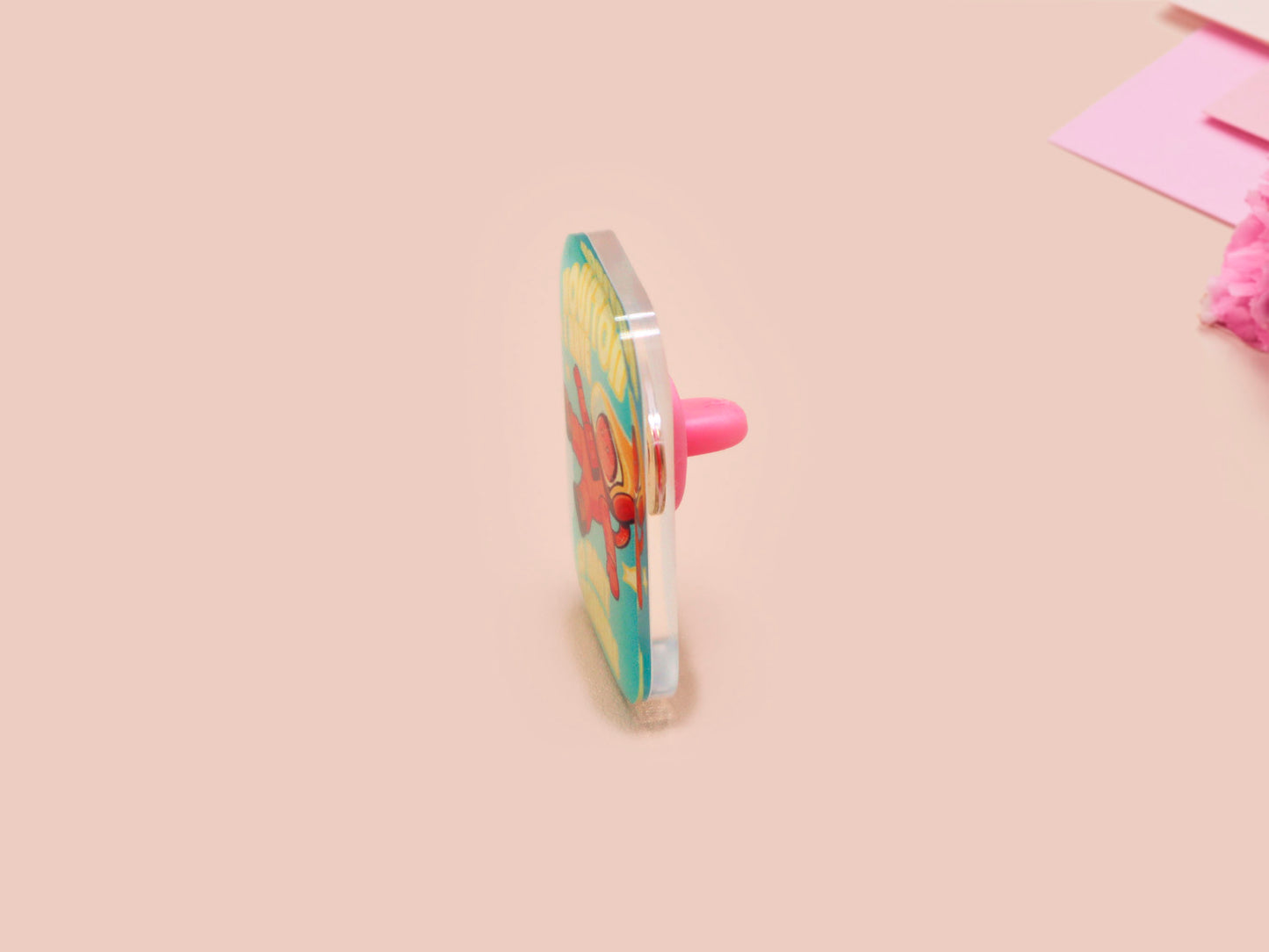 A clear acrylic pin badge with a pink heart-shaped pin back clasp. The design of the pin badge is of a cute chibi retro astronaut floating in sapce with the quote Houston I have so many problems