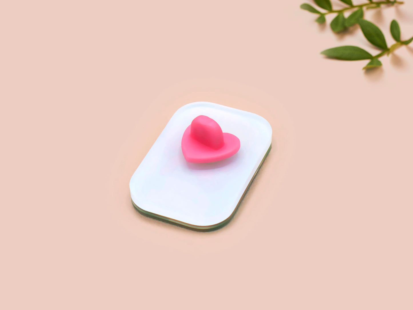 A clear acrylic pin badge with a pink heart-shaped pin back clasp. The design of the pin badge is of a cute chibi retro astronaut floating in sapce with the quote Houston I have so many problems