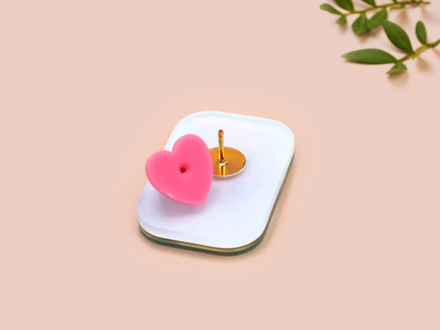 A clear acrylic pin badge with a pink heart-shaped pin back clasp. The design of the pin badge is of a cute chibi retro astronaut floating in sapce with the quote Houston I have so many problems
