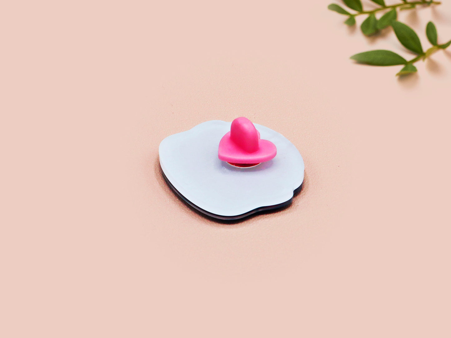 Clear acrylic pin badge with pink heart-shaped rubber pin back clasp. The design of the pin badge is a cute cartoon chibi Mothman cryptid with the quote I believe in Mothman and Mothman believes in me.