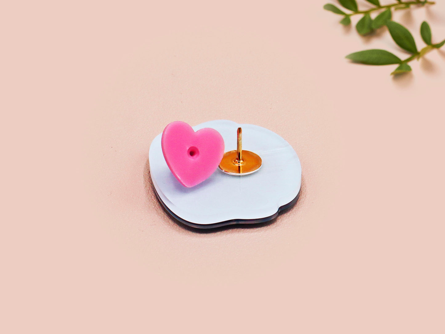 Clear acrylic pin badge with pink heart-shaped rubber pin back clasp. The design of the pin badge is a cute cartoon chibi Mothman cryptid with the quote I believe in Mothman and Mothman believes in me.