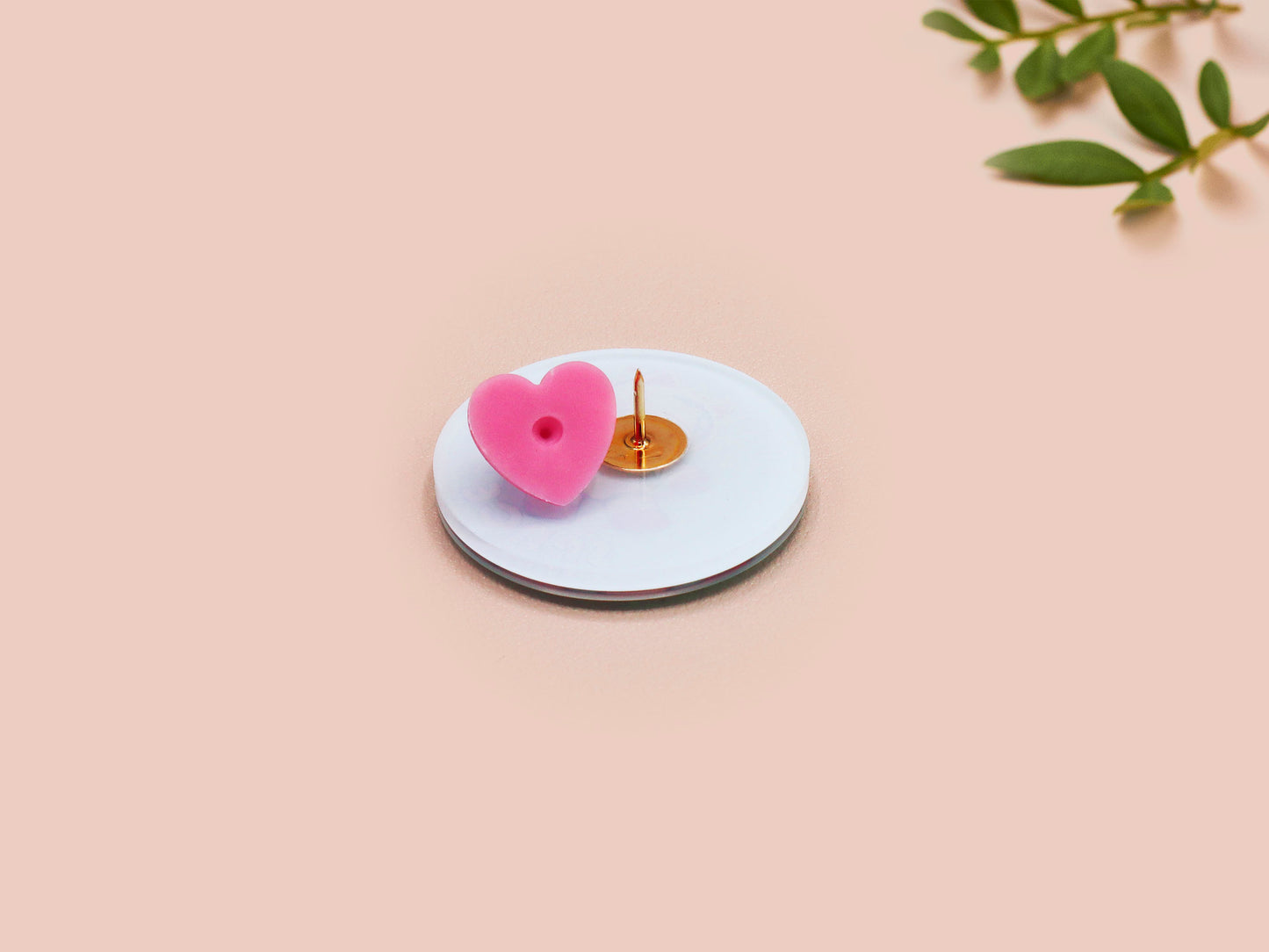 Clear acrylic pin badge with a pink heart-shaped rubber pin back clasp. The design of the pin badge is a cute chibi white cat in a retro astronaut suit with the quote I need space.