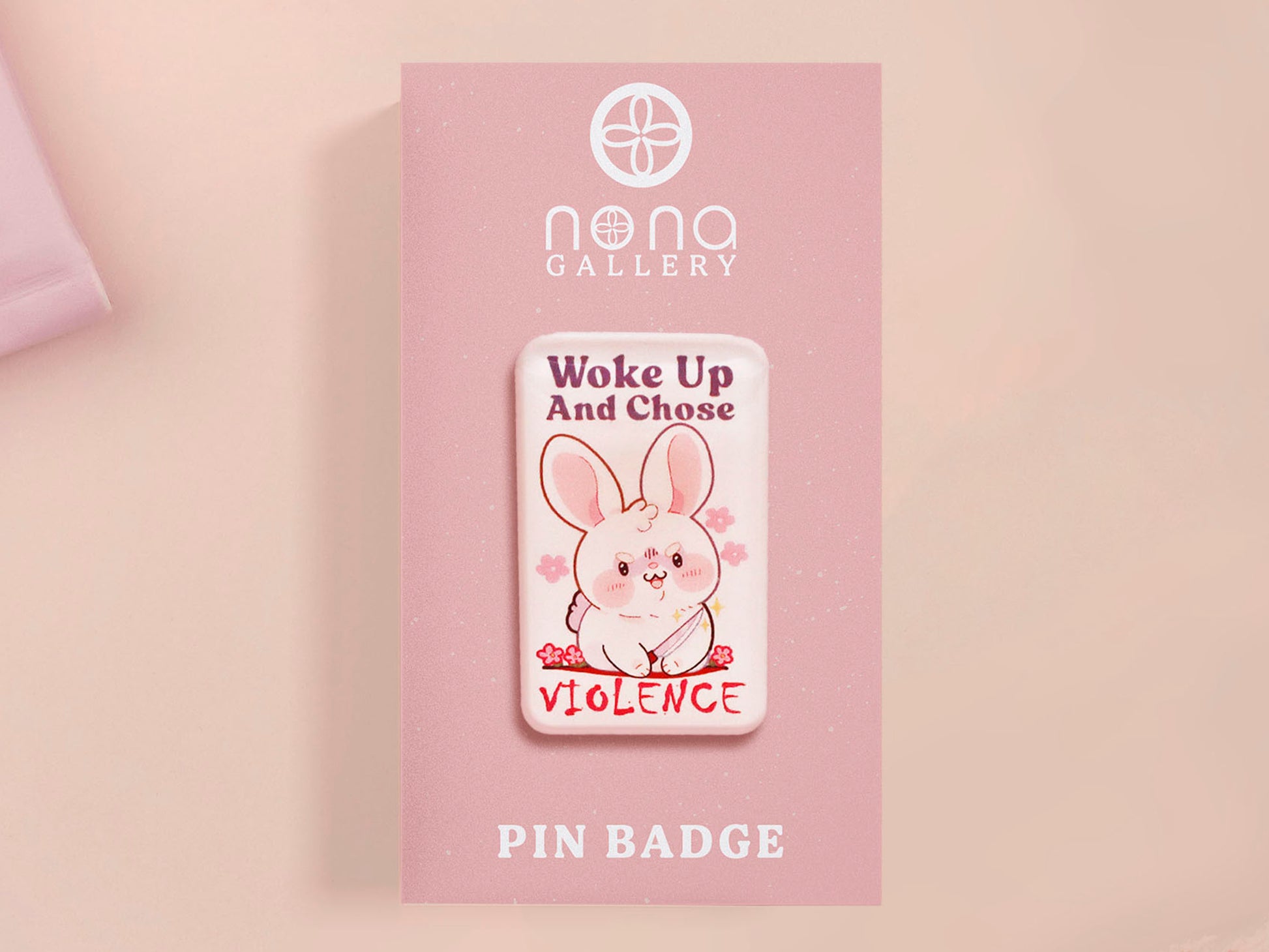 Clear acrylic pin badge with pink heart-shaped rubber pin back clasp. The design of the pin badge is a cute cartoon chibi white rabbit with the quote Woke Up And Chose Violence.