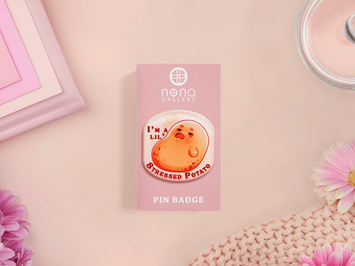 A clear acrylic pin badge with a pink heart-shaped pin back clasp. The design of the pin badge is of a cute chibi potato with the quote I'm a lil' stressed potato