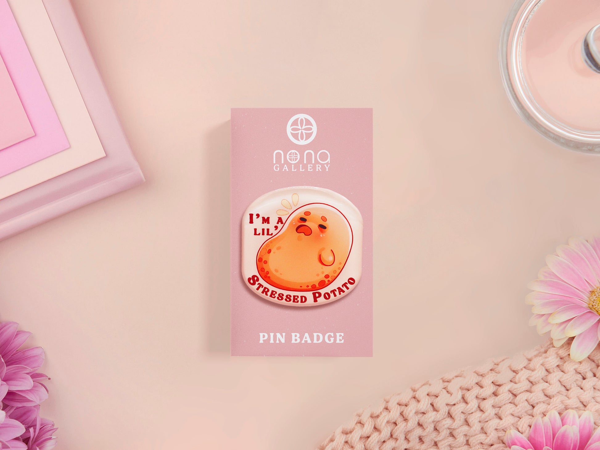 A clear acrylic pin badge with a pink heart-shaped pin back clasp. The design of the pin badge is of a cute chibi potato with the quote I'm a lil' stressed potato
