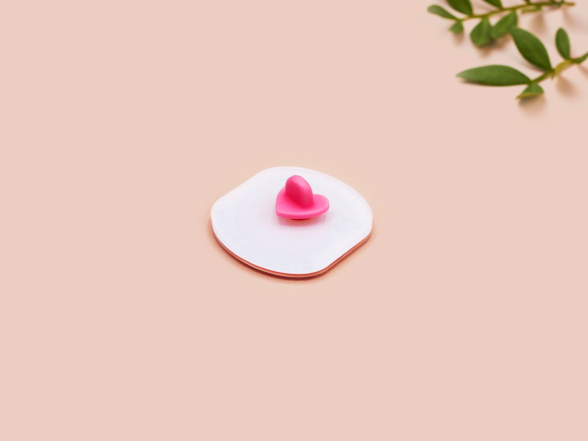 A clear acrylic pin badge with a pink heart-shaped pin back clasp. The design of the pin badge is of a cute chibi potato with the quote I'm a lil' stressed potato