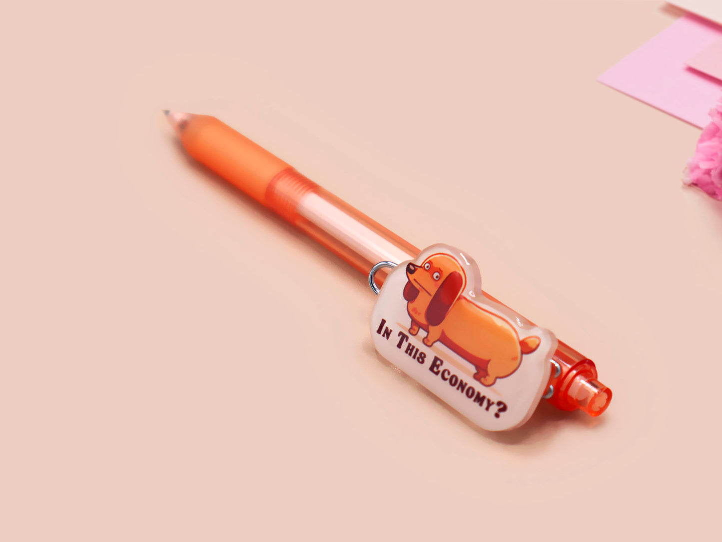 Orange ballpoint pen with black ink and a cute chibi dachshund sausage dog design.