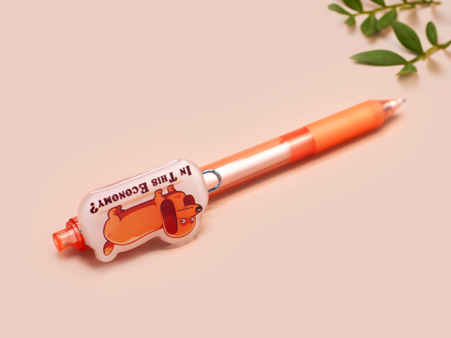 Orange ballpoint pen with black ink and a cute chibi dachshund sausage dog design.