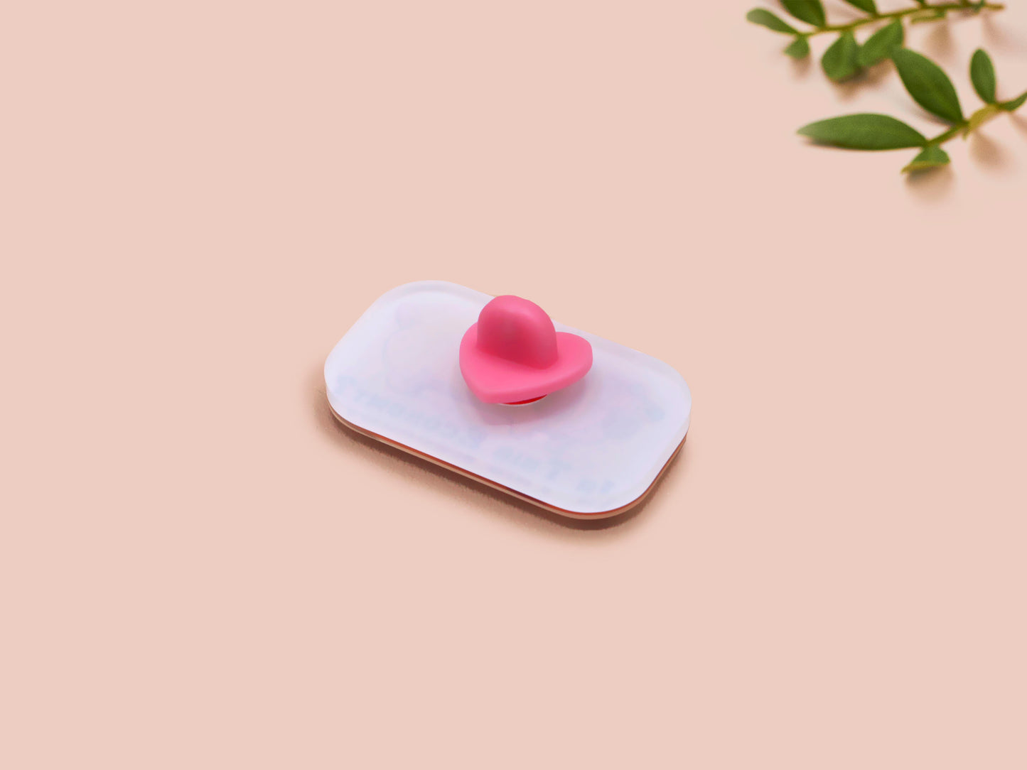A clear acrylic pin badge with a pink heart-shaped pin back clasp. The design of the pin badge is of a cute chibi dachshund sausage dog with the quote in this economy?