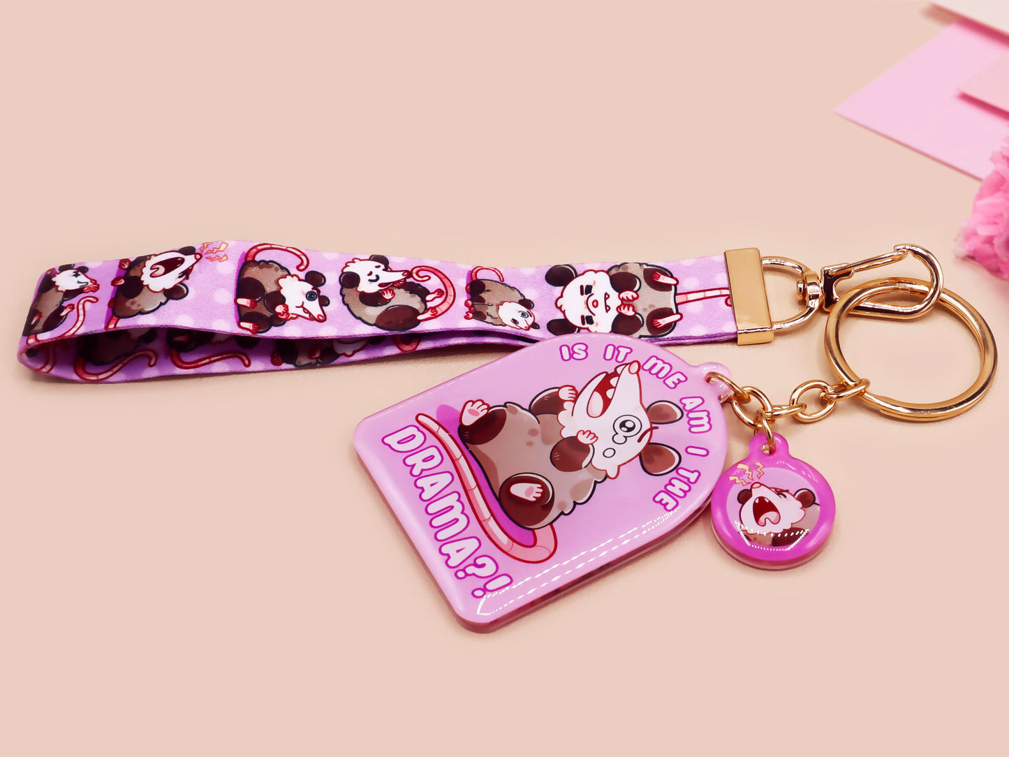 Acrylic epoxy possum keychain with a large acrylic charm of a purple screaming possum with the quote is it me am I the drama, a smaller charm of a cute crying possum and a matching purple possum lanyard.