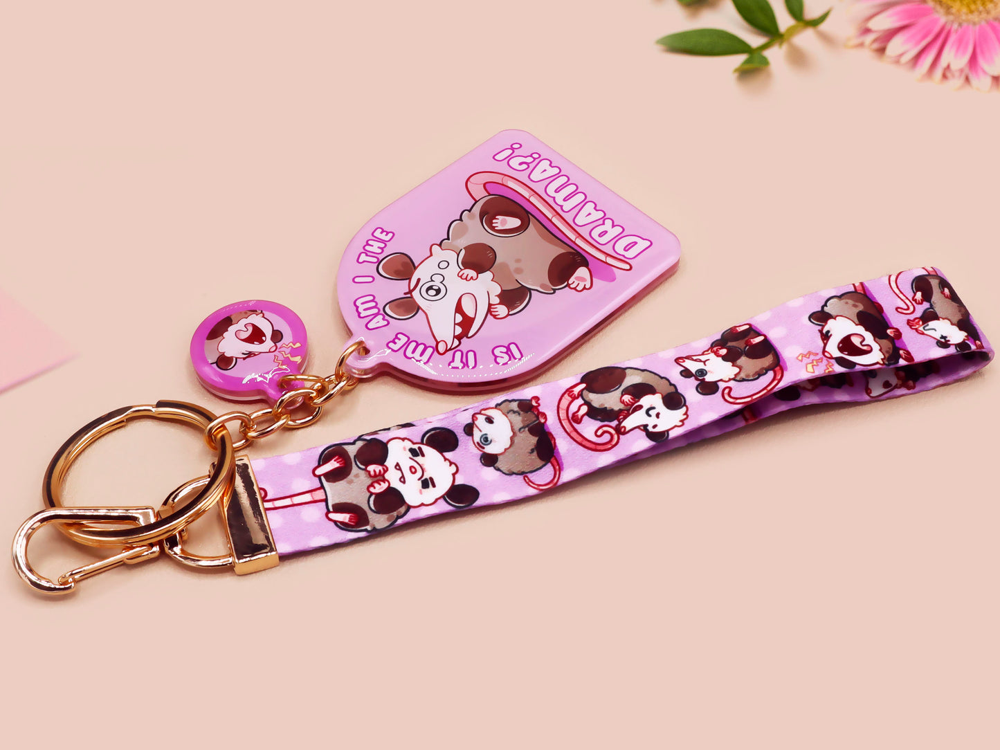 Acrylic epoxy possum keychain with a large acrylic charm of a purple screaming possum with the quote is it me am I the drama, a smaller charm of a cute crying possum and a matching purple possum lanyard.